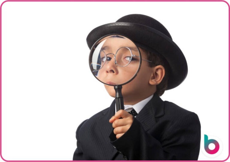 A child looking through a magnifying glass with a bowler hat on