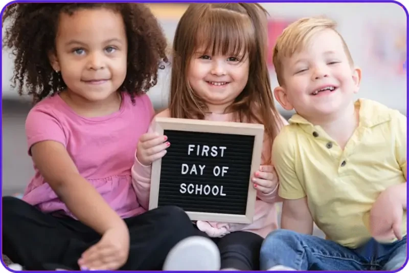School-readiness-image-children-holding-up-a-board-saying-First-Day-of-School