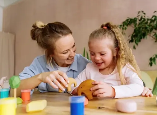 A woman playing with a child at a table