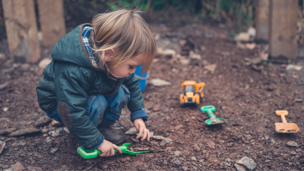 child playing with bark outside