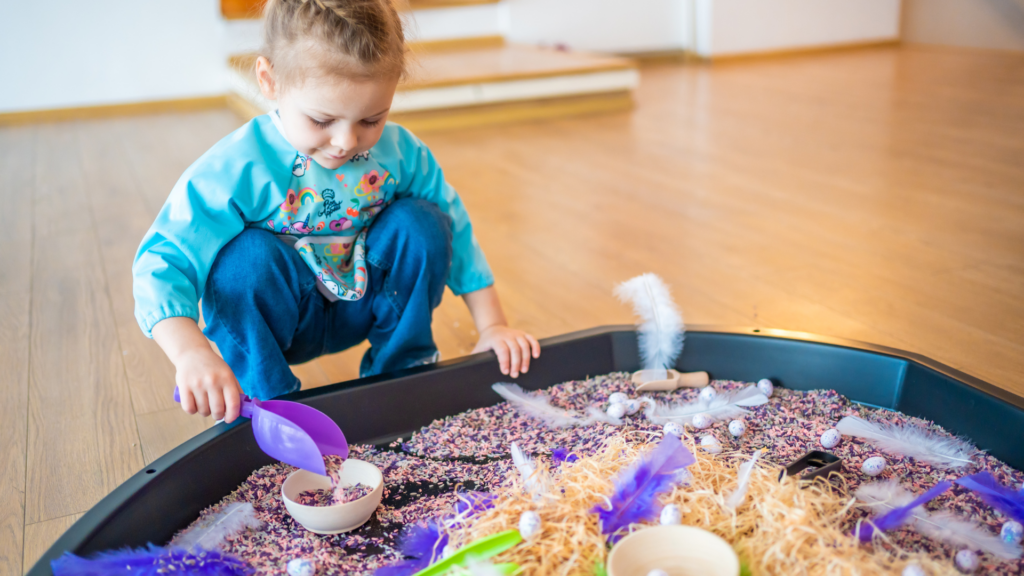 child playing with sensory tuff tray