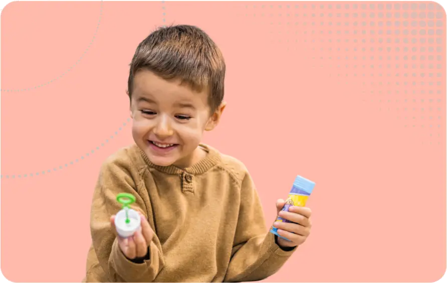 SENco Role Image - Child happily staring at a bubble wand